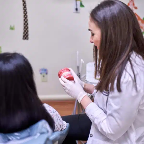 Pediatric orthodontist educating young patient in Closter, NJ