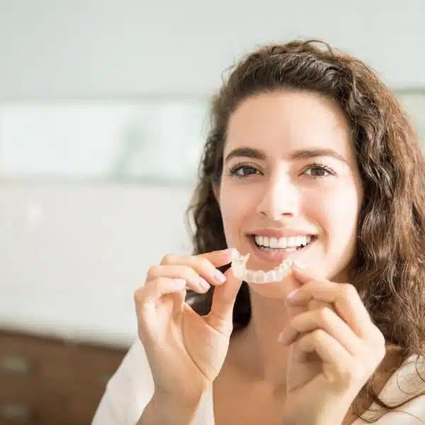 Smiling adult with Invisalign aligners